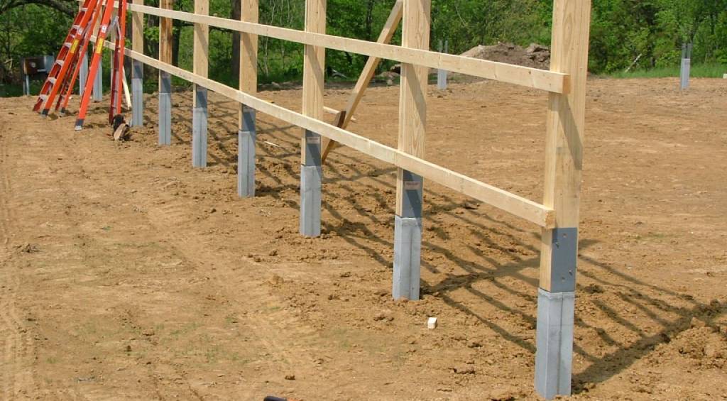 frame building construction with posts in the ground